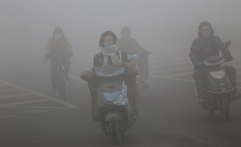 ZHENGZHOU, CHINA - DECEMBER 23: (CHINA OUT) Cyclists wearing masks ride along a road in heavy smog on December 23, 2015 in Zhengzhou, China. According to the Ministry of Environmental Protection of the People's Republic of China, more than 50 cities, including Beijing, Tianjin, Shanghai and Guangzhou, were affected by severe air pollution on Wednesday. (Photo by ChinaFotoPress/ChinaFotoPress via Getty Images)